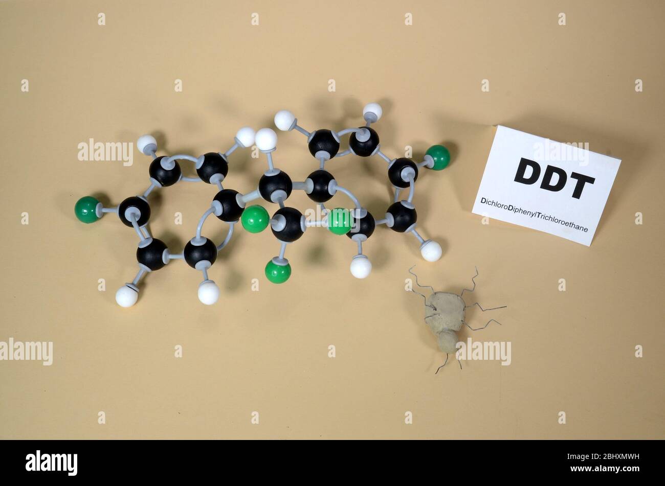 Molecule model of DDT - Dichlorodiphenyltrichloroethan with illustrative dead bug. White is Hydrogen, black is Carbon, and Green is Chlorine. Stock Photo