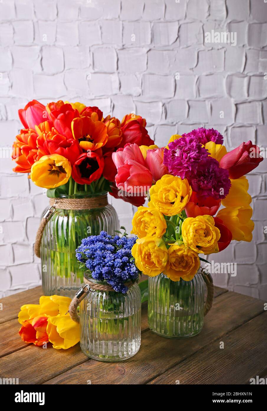 Beautiful flowers in vases on wall background Stock Photo - Alamy