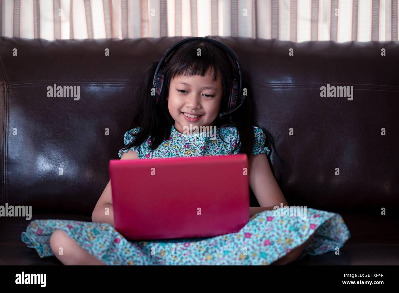Cute asian little child girl studying  online lesson at home, social distance during quarantine, online education concept Stock Photo