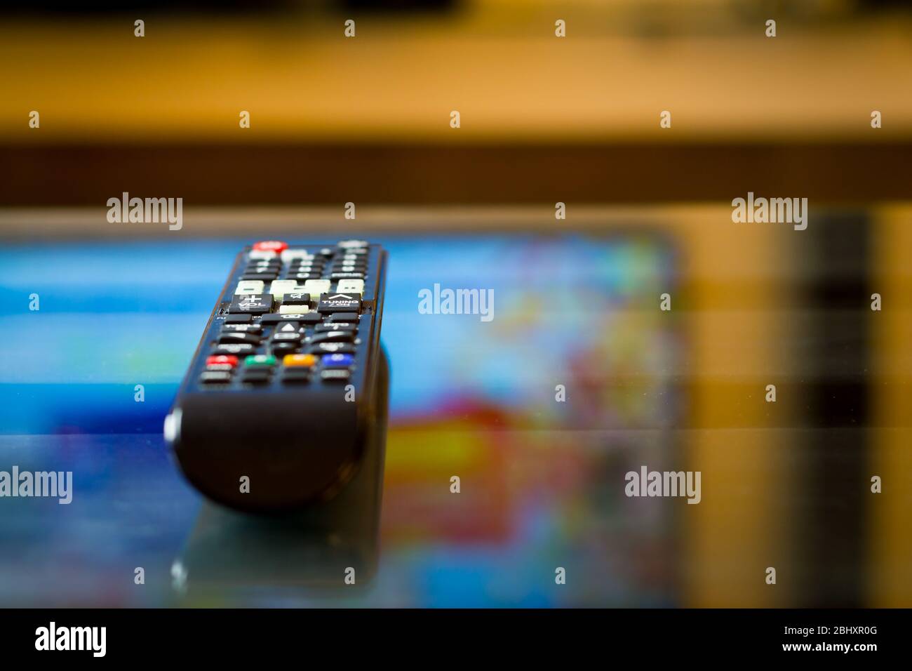 TV television remote on the glass table, ready for watching film or serial Stock Photo Alamy