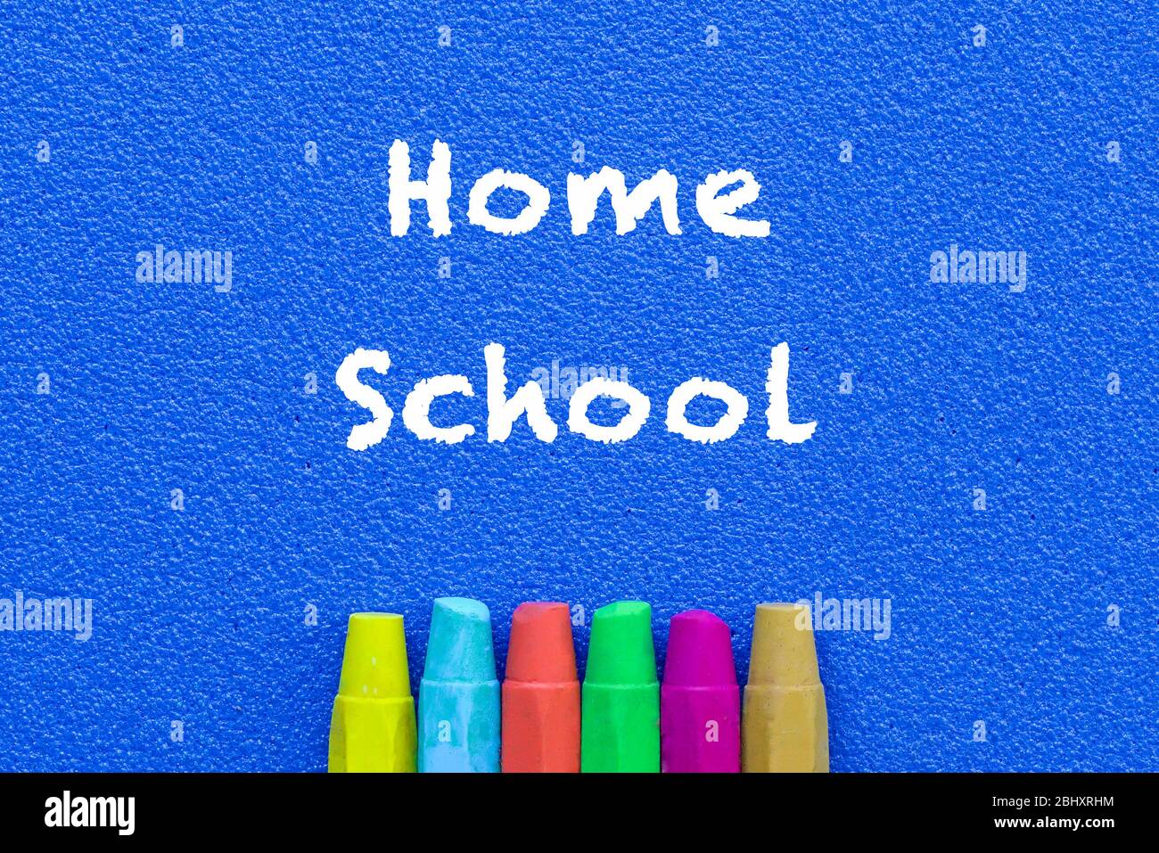 Homeschool. Words or typed text on blue board. Colorful crayons. Top view. Education concept. Stock Photo