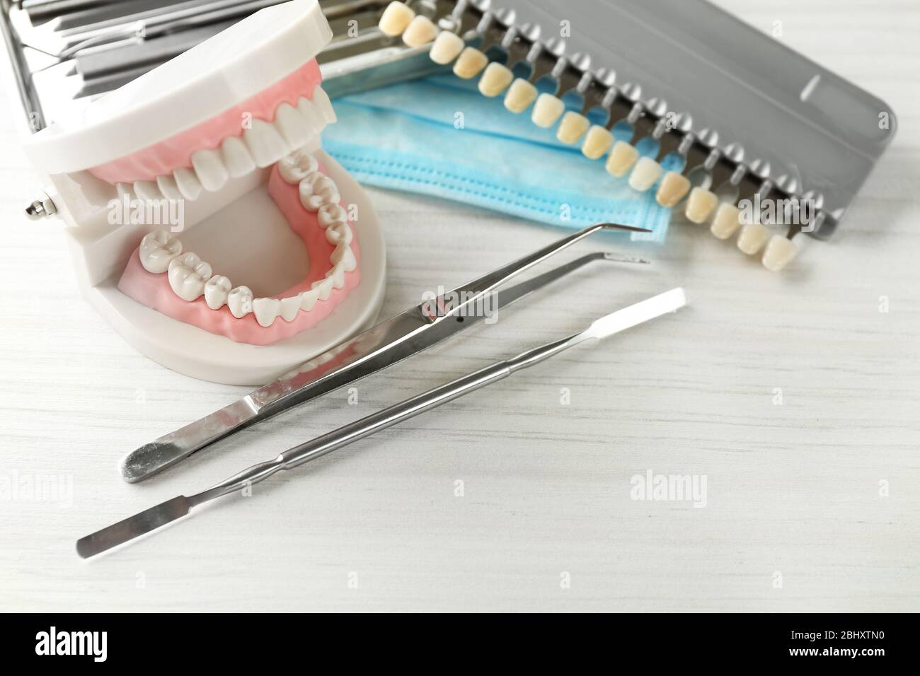 Or Instruments With Teeth White teeth and dental instruments on table background Stock Photo - Alamy