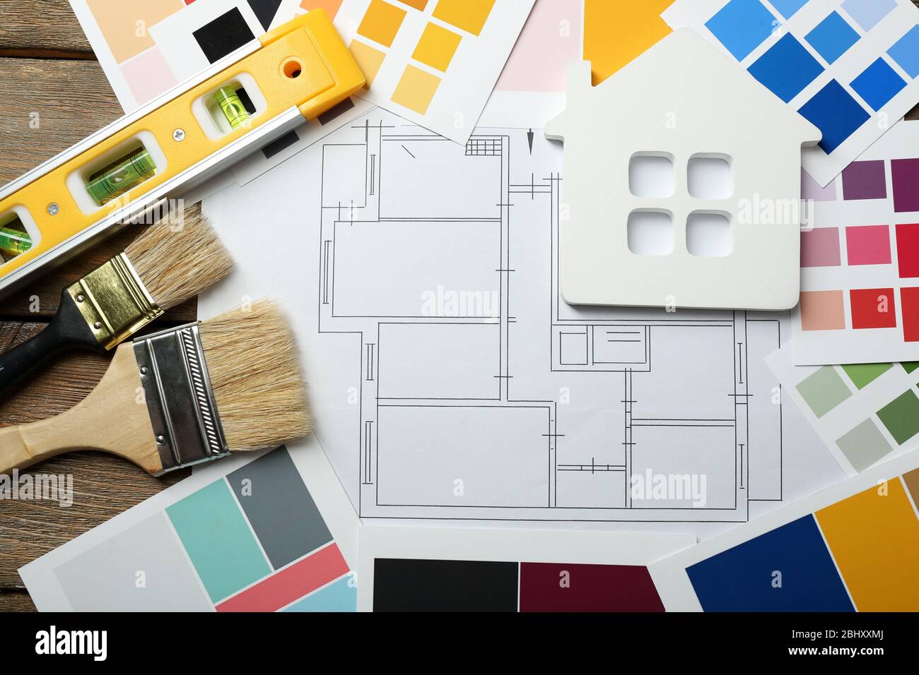 Construction instruments, plan and brushes on wooden table background ...