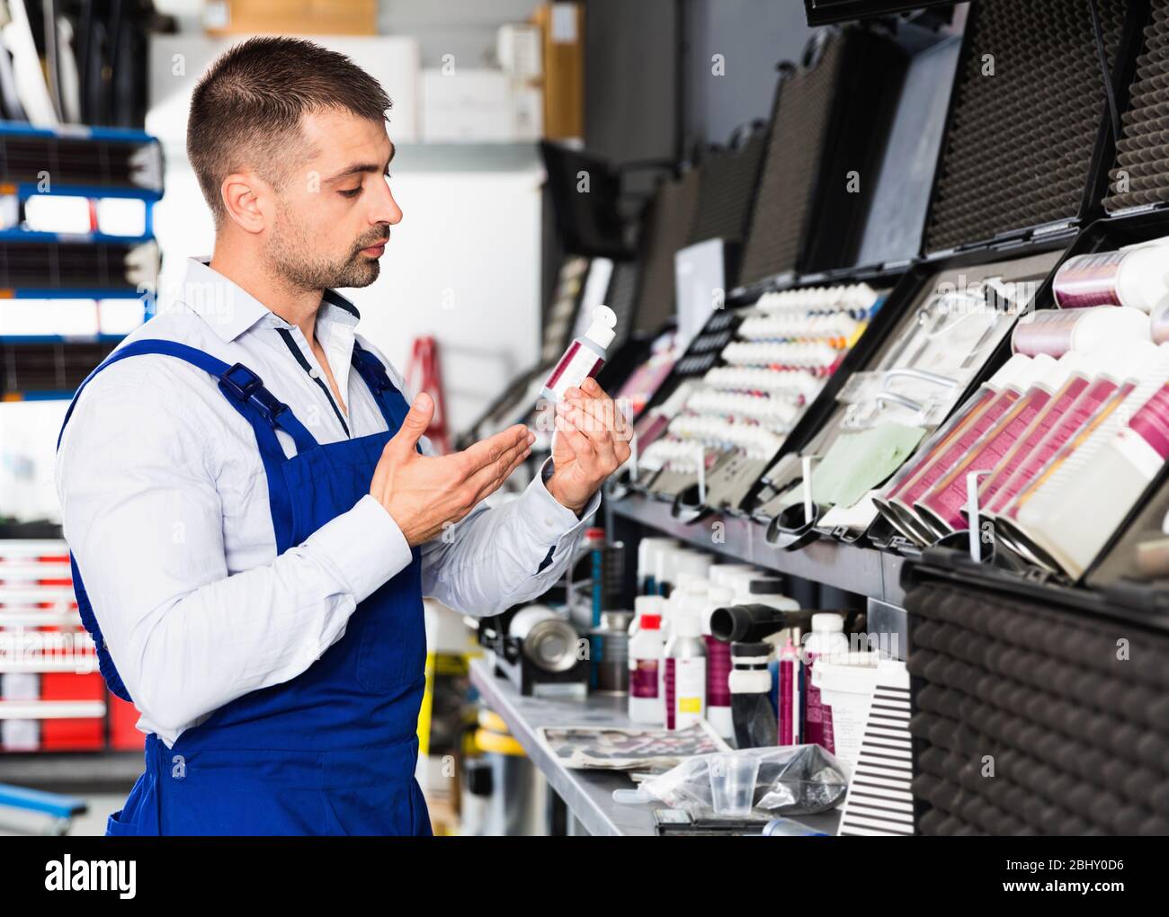 Professional diligent  glad friendly car painter preparing paints for paintwork in modern auto repair shop Stock Photo