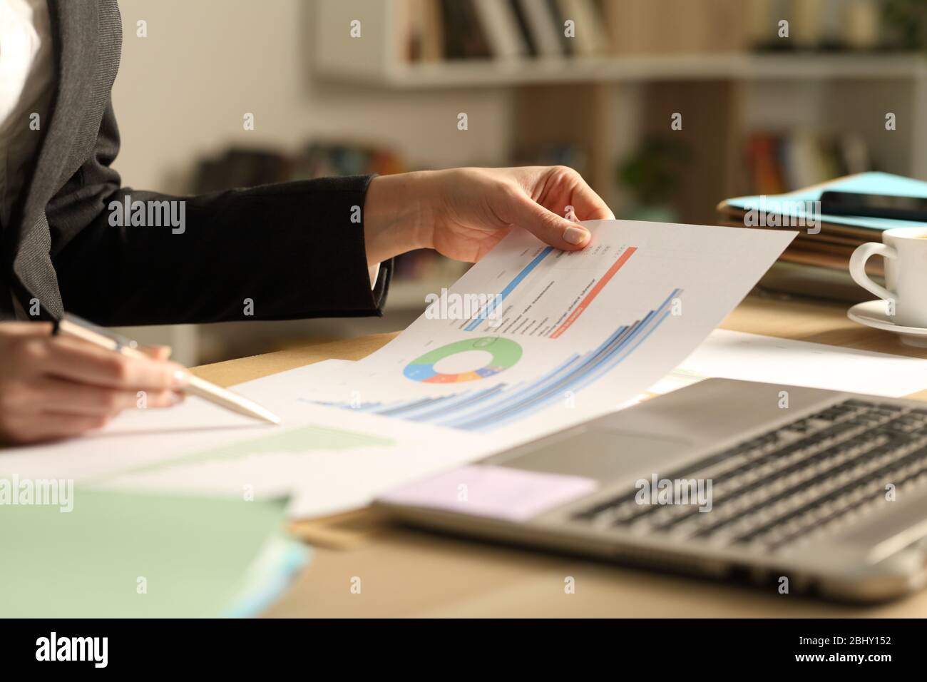 Close up of entrepreneur woman hands comparing growth graph reports on a desk at home office Stock Photo