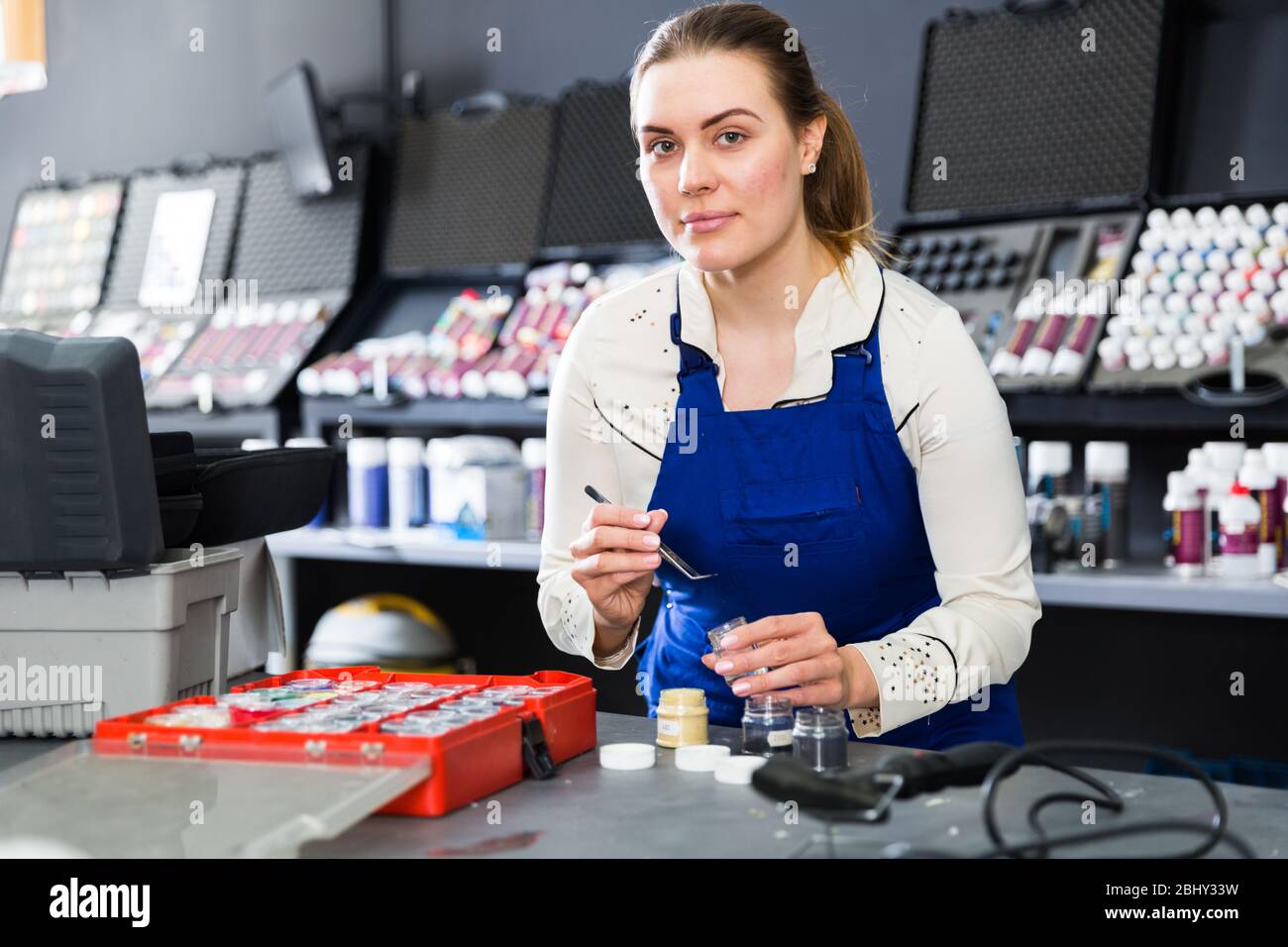 Professional female mechanic selecting fibers color for automobile upholstery in auto workshop Stock Photo