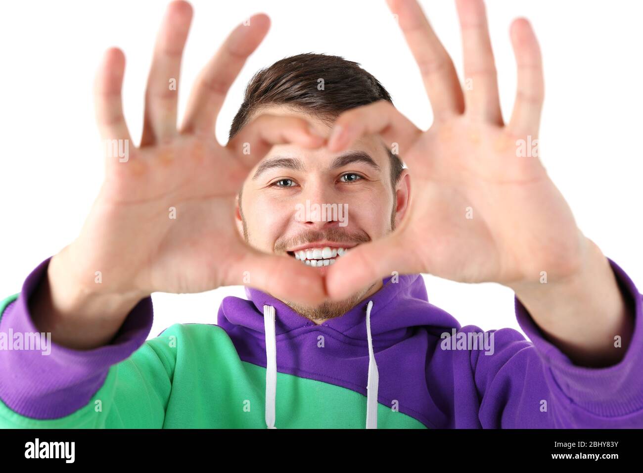 Smiling attractive young man makes heart using fingers Stock Photo - Alamy