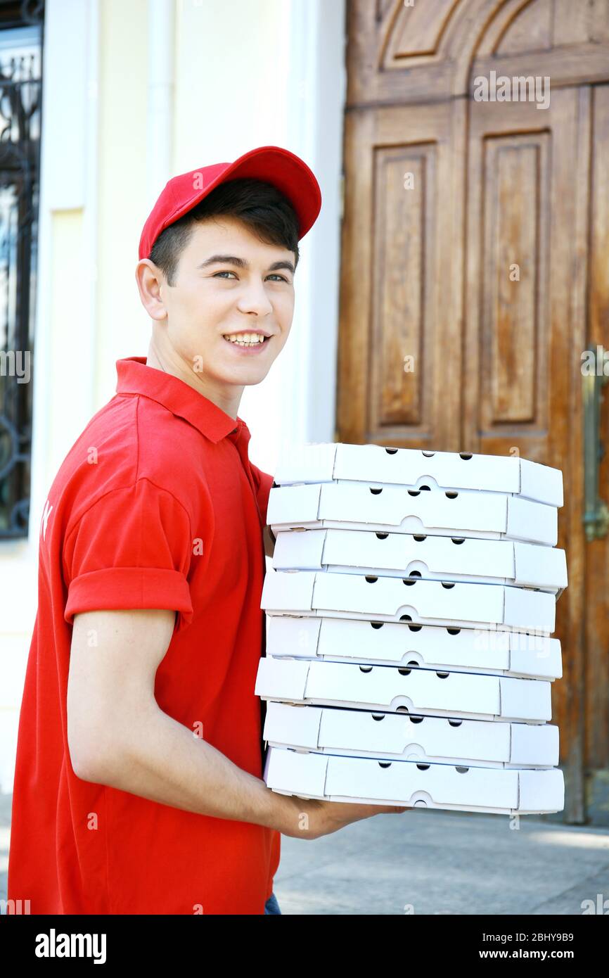 Young man delivering pizza box near house Stock Photo Alamy
