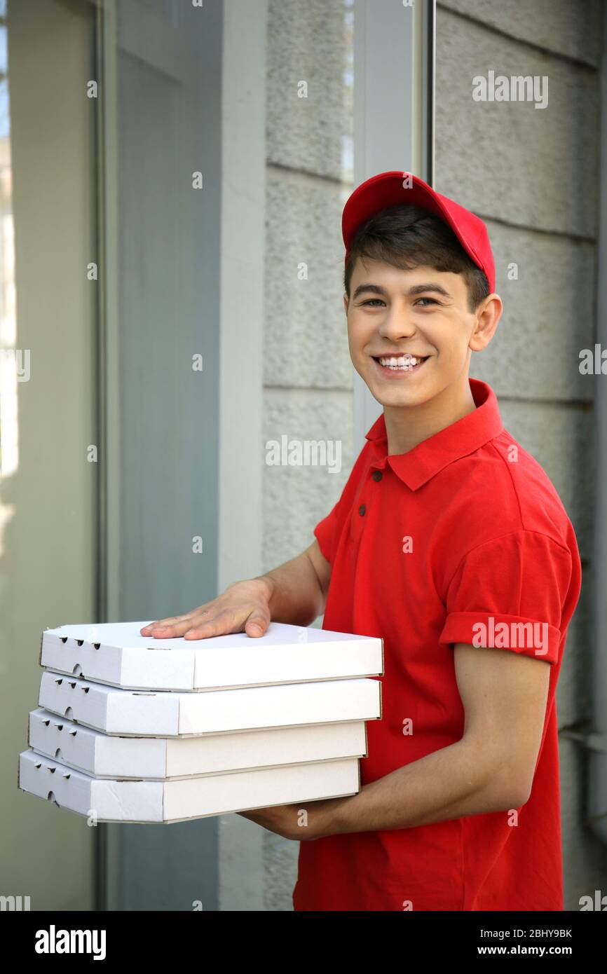 Young man delivering pizza box near house Stock Photo Alamy