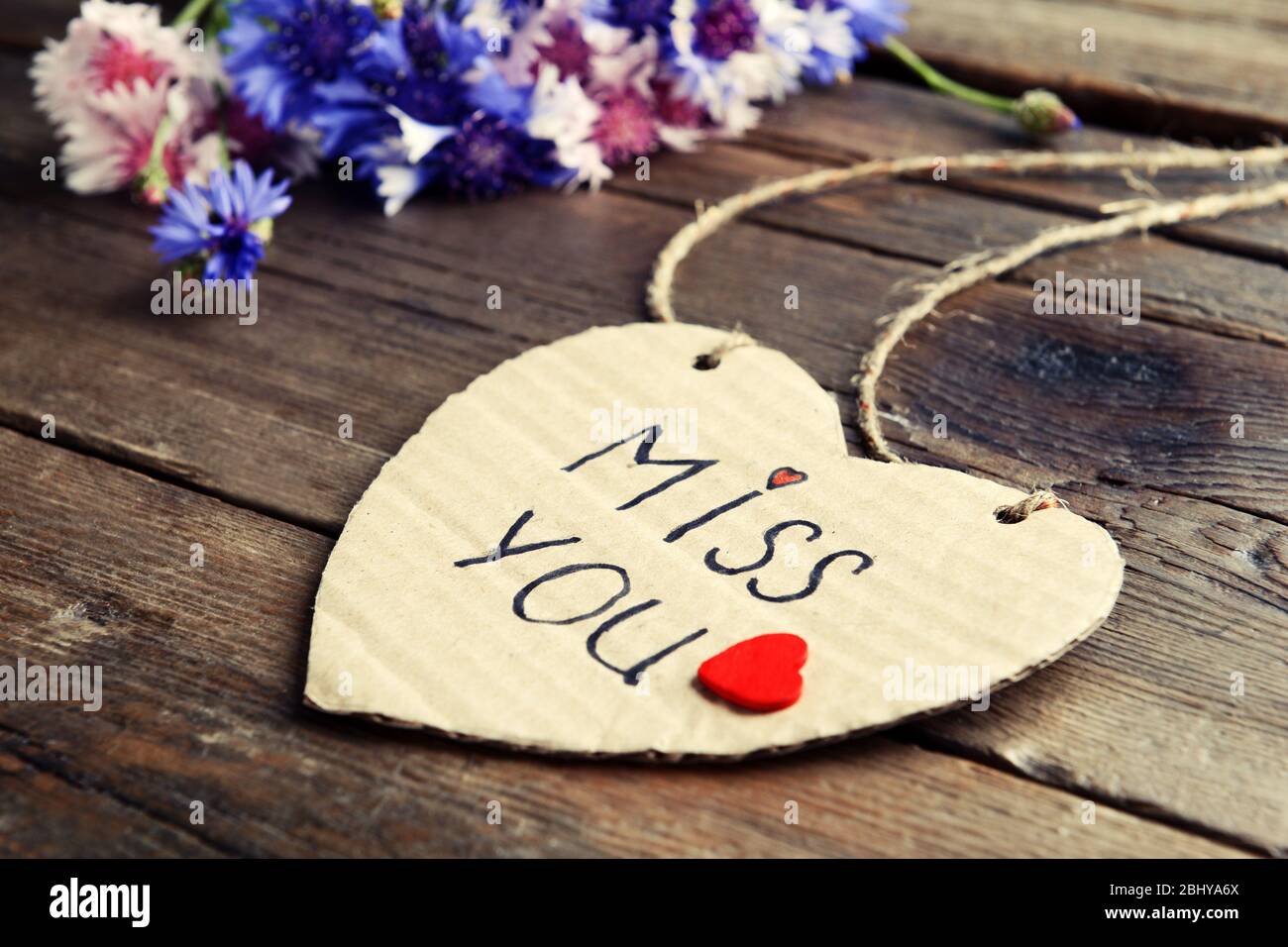 Written message with dry flowers on wooden table close up Stock Photo