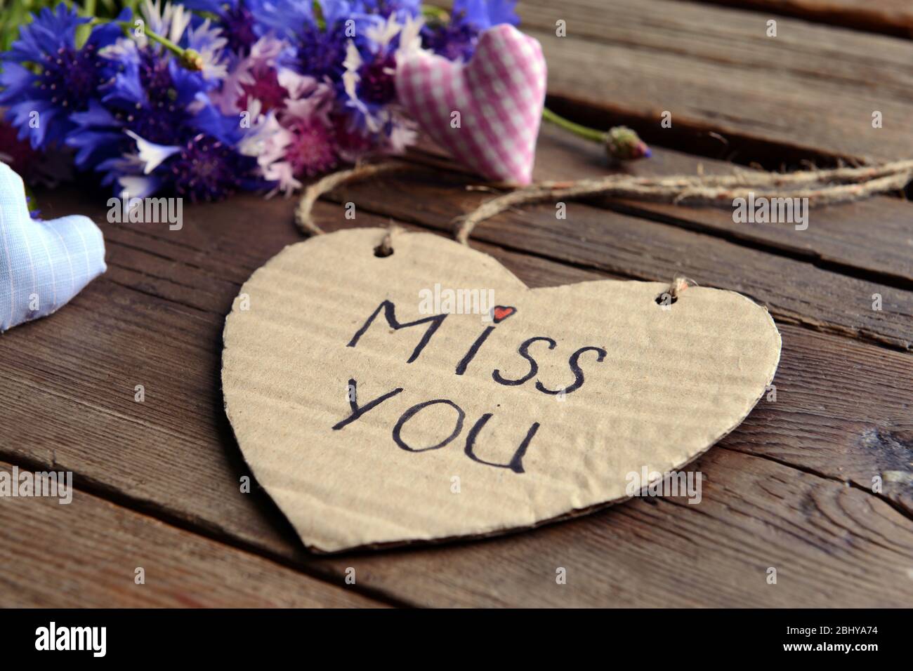 Written message with dry flowers  and decorative hearts on wooden table close up Stock Photo