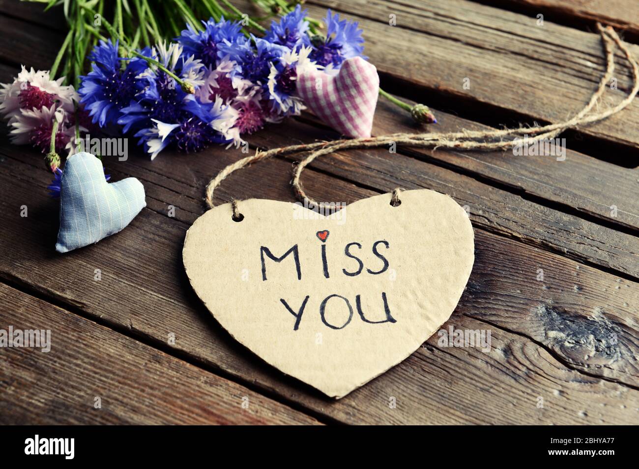 Written message with dry flowers  and decorative hearts on wooden table close up Stock Photo