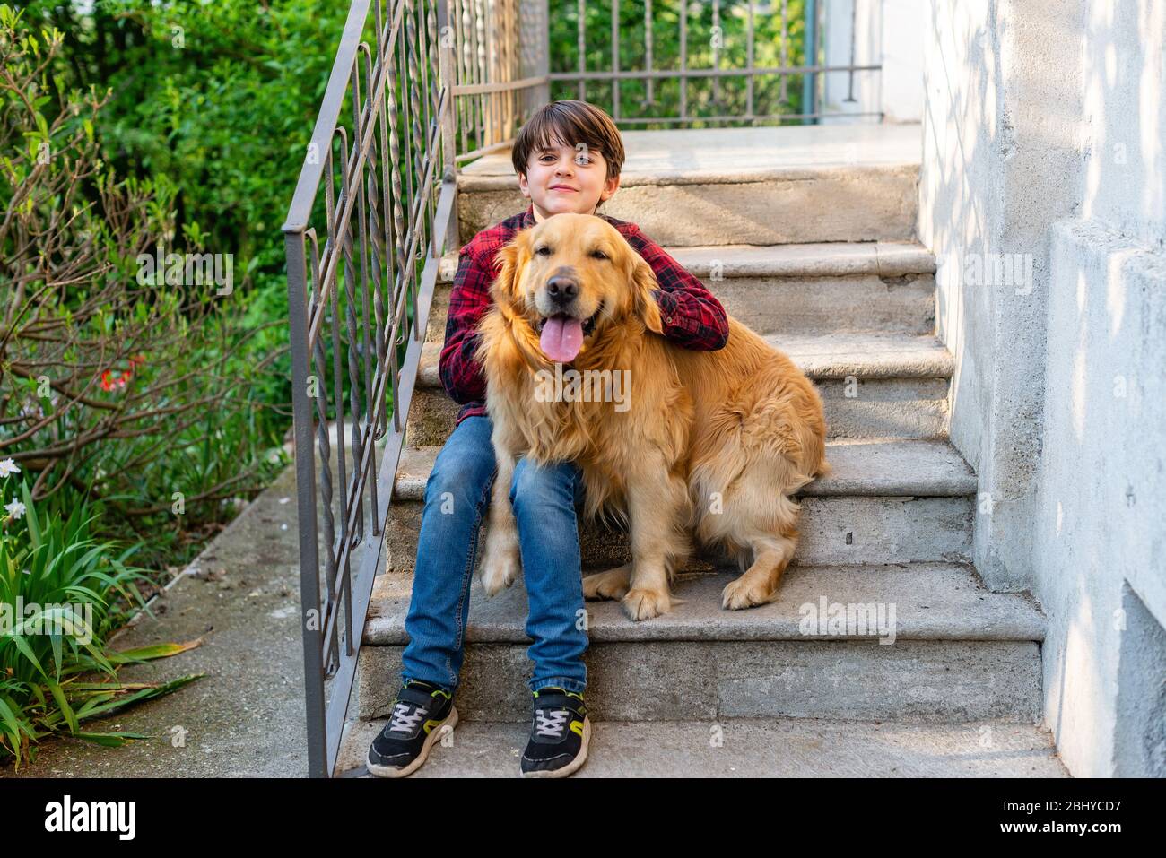child sit on the stairs with dog portrait of kid eleven years old and