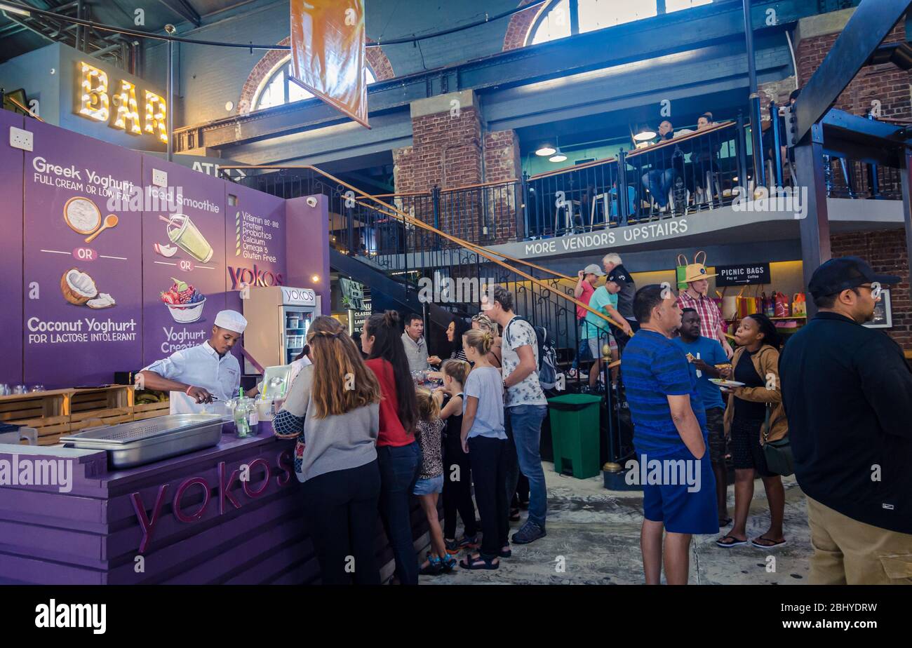 Selling Greek yogurt to tourists customers at Yokos indoor food market hall Victoria and Albert
