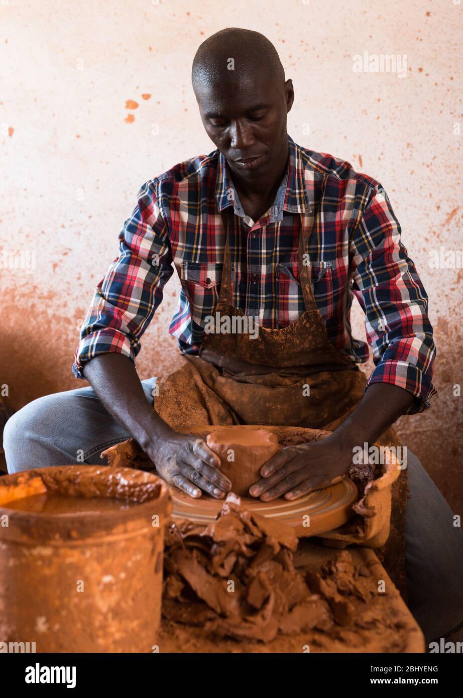 Professional male potter making bowl on potters wheel in pottery studio ...