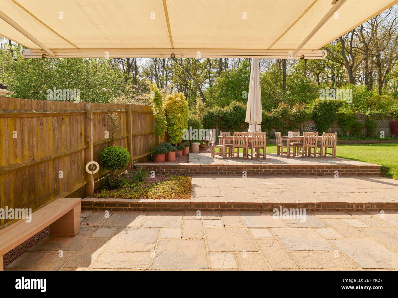 20 degree centigrade sunny spring day in an english back garden with patio and awning. Stock Photo