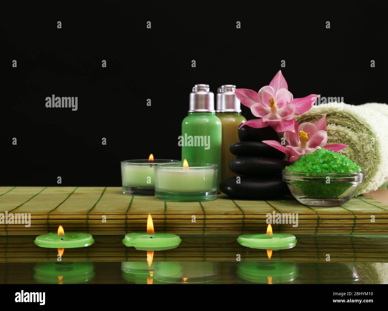 Spa still life with flowers and candlelight on black background Stock