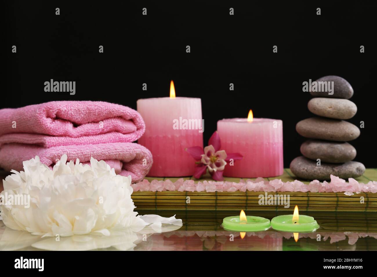 Spa still life with flower and candlelight on black background Stock
