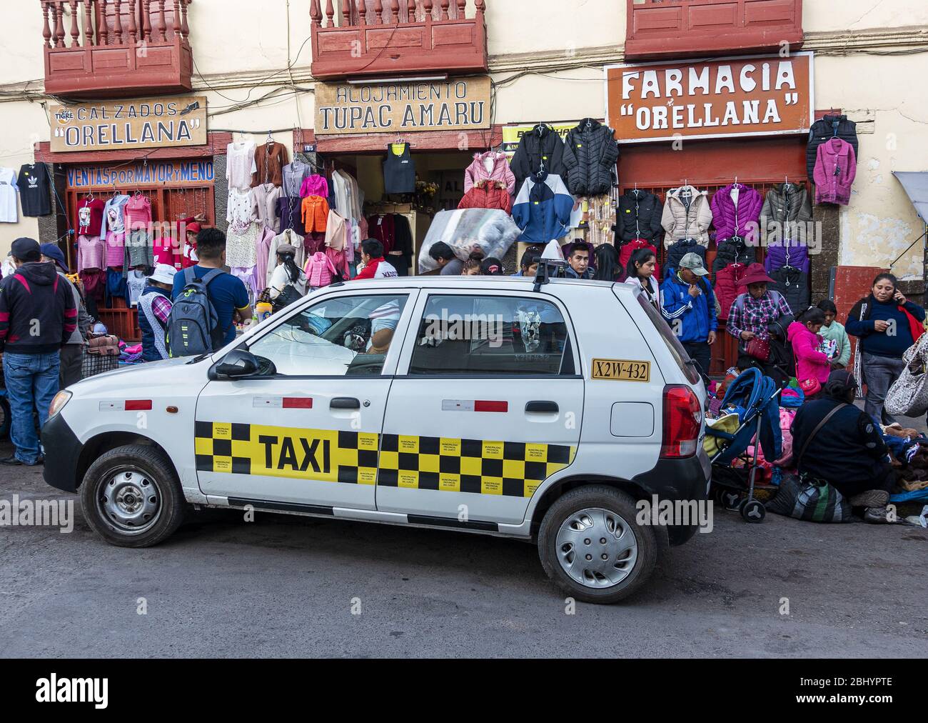 Local taxi in front of clothing stall and pharmacy outside San Pedro Market in Cusco, Peru Stock Photo