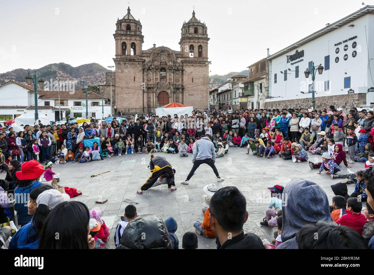 Street performers entertaining the locals in front of St. Peter's Church in the Plazoleta San Pedro, Cusco, Peru Stock Photo