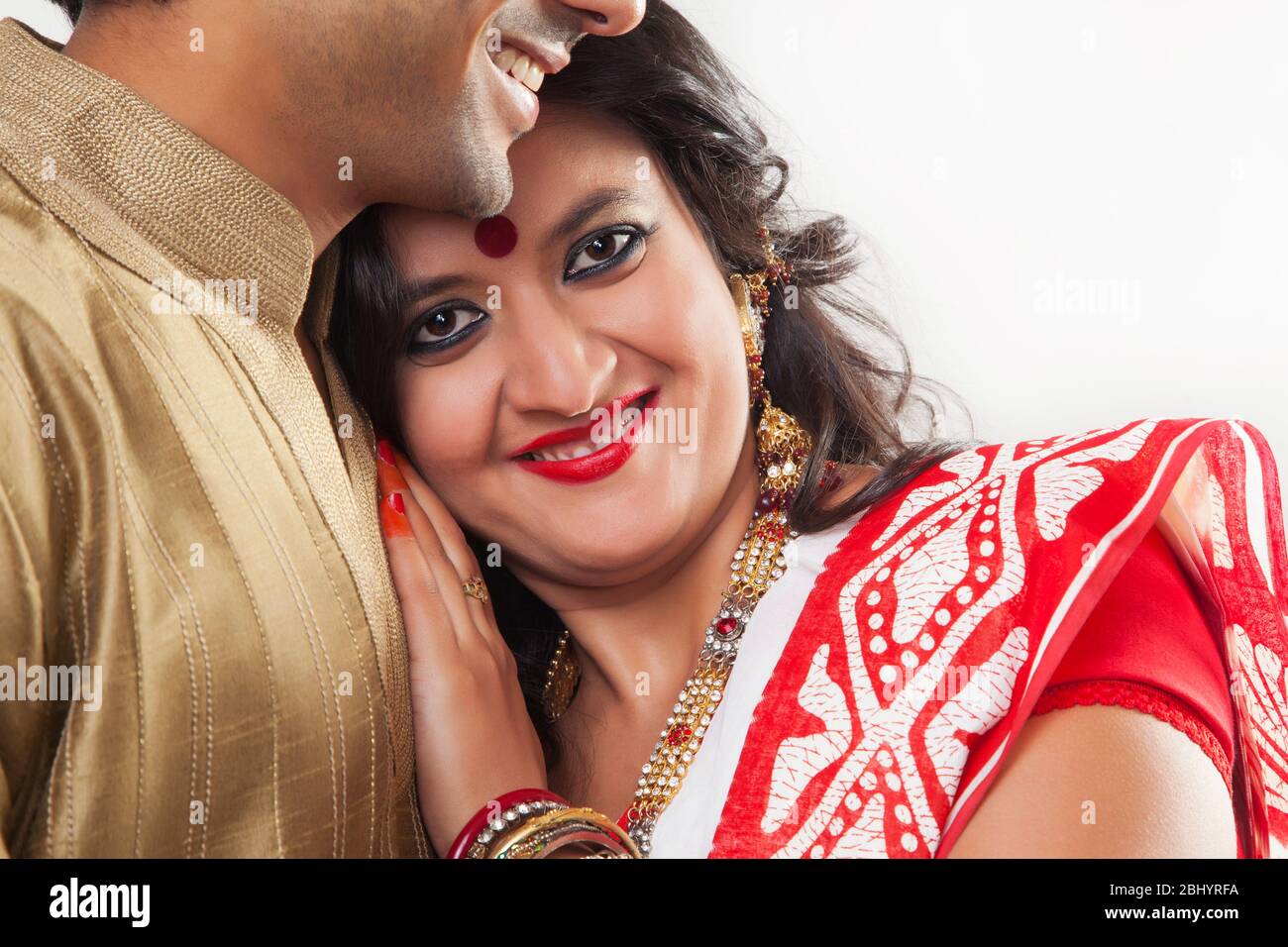 Bengali woman resting her head on her husband’s chest. (Couple Stock