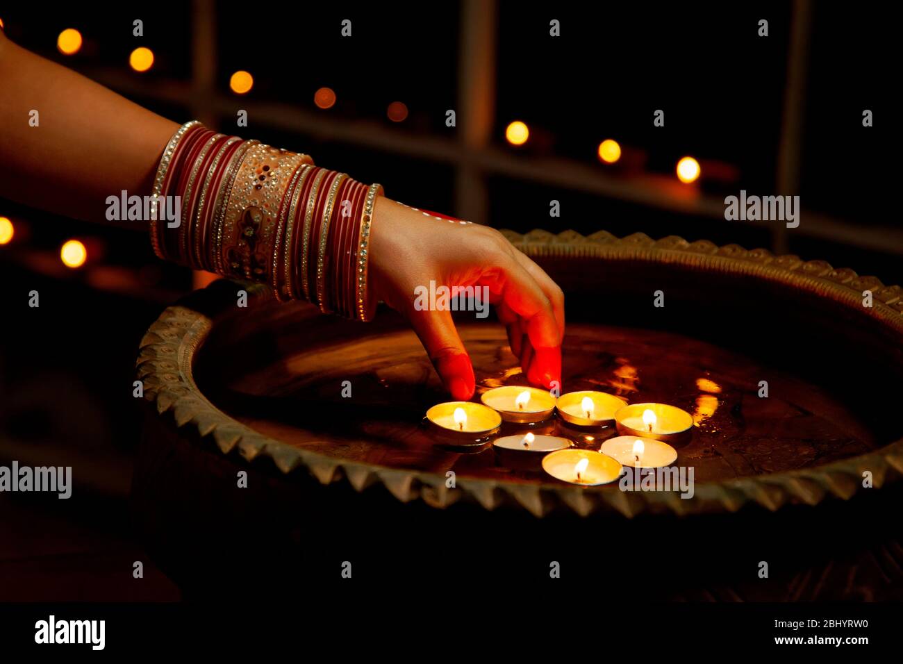 Young woman placing wax candles in water on the occasion of Diwali
