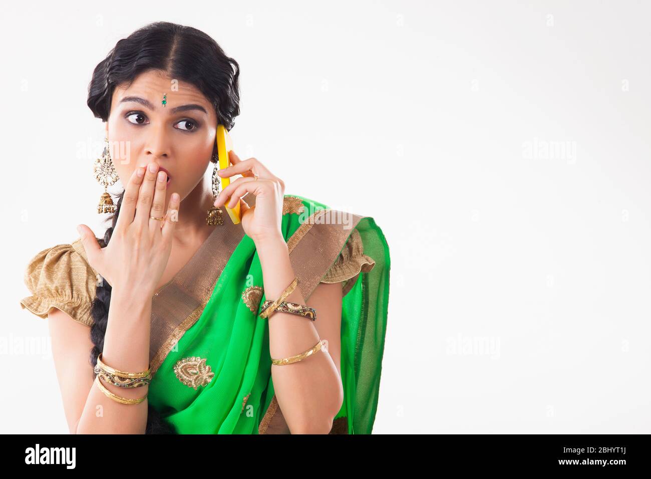 Young woman looking surprised after getting some gossip on the phone. (Housewife) Stock Photo