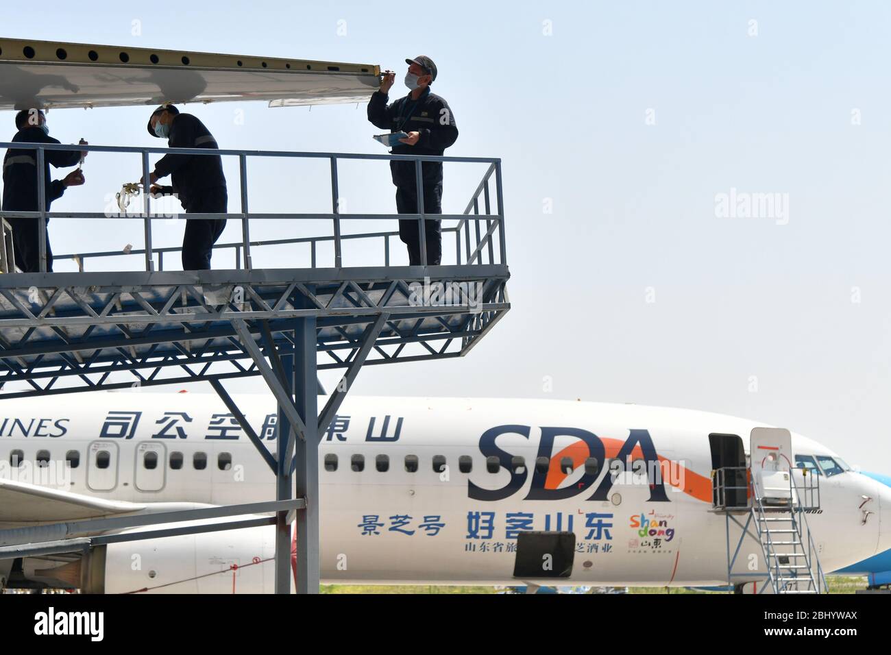 (200428) -- JINAN, April 28, 2020 (Xinhua) -- Technicians refit an airliner at Taikoo (Shandong) Aircraft Engineering Company Limited (STAECO) in Jinan, east China's Shandong Province, April 27, 2020.  The COVID-19 pandemic has led to a significant decrease in airline travel and passenger revenue. Since its production recovered on Feb. 10, STAECO has been offering Passenger-to-Freighter (PTF) solutions for airline operators which need more cargo planes to address this market change. So far, the company has accomplished three PTF conversions for its clients. (Xinhua/Zhu Zheng) Stock Photo