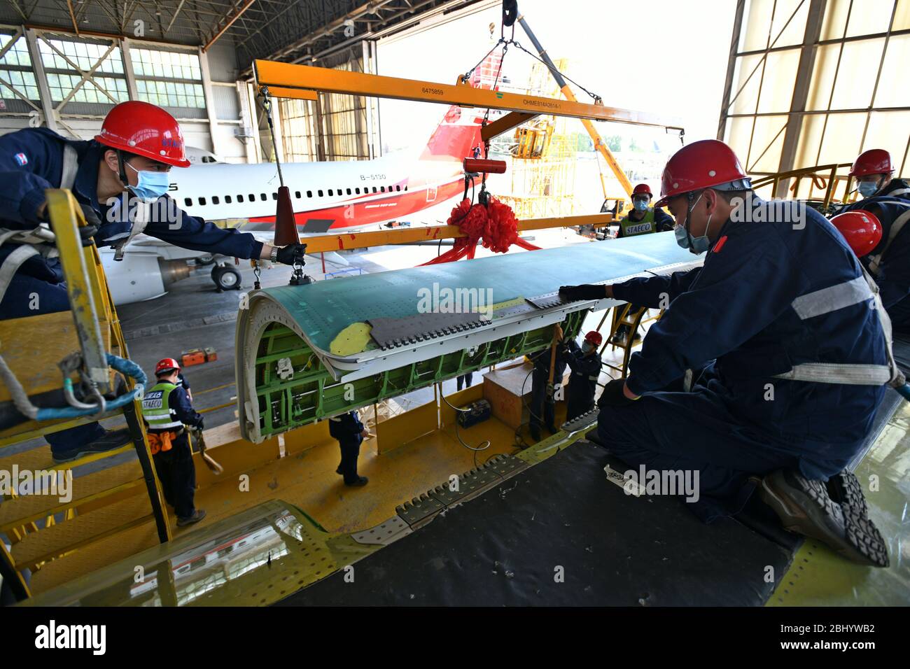 (200428) -- JINAN, April 28, 2020 (Xinhua) -- Technicians refit an airliner at Taikoo (Shandong) Aircraft Engineering Company Limited (STAECO) in Jinan, east China's Shandong Province, April 27, 2020. The COVID-19 pandemic has led to a significant decrease in airline travel and passenger revenue. Since its production recovered on Feb. 10, STAECO has been offering Passenger-to-Freighter (PTF) solutions for airline operators which need more cargo planes to address this market change. So far, the company has accomplished three PTF conversions for its clients. (Xinhua/Zhu Zheng) Stock Photo
