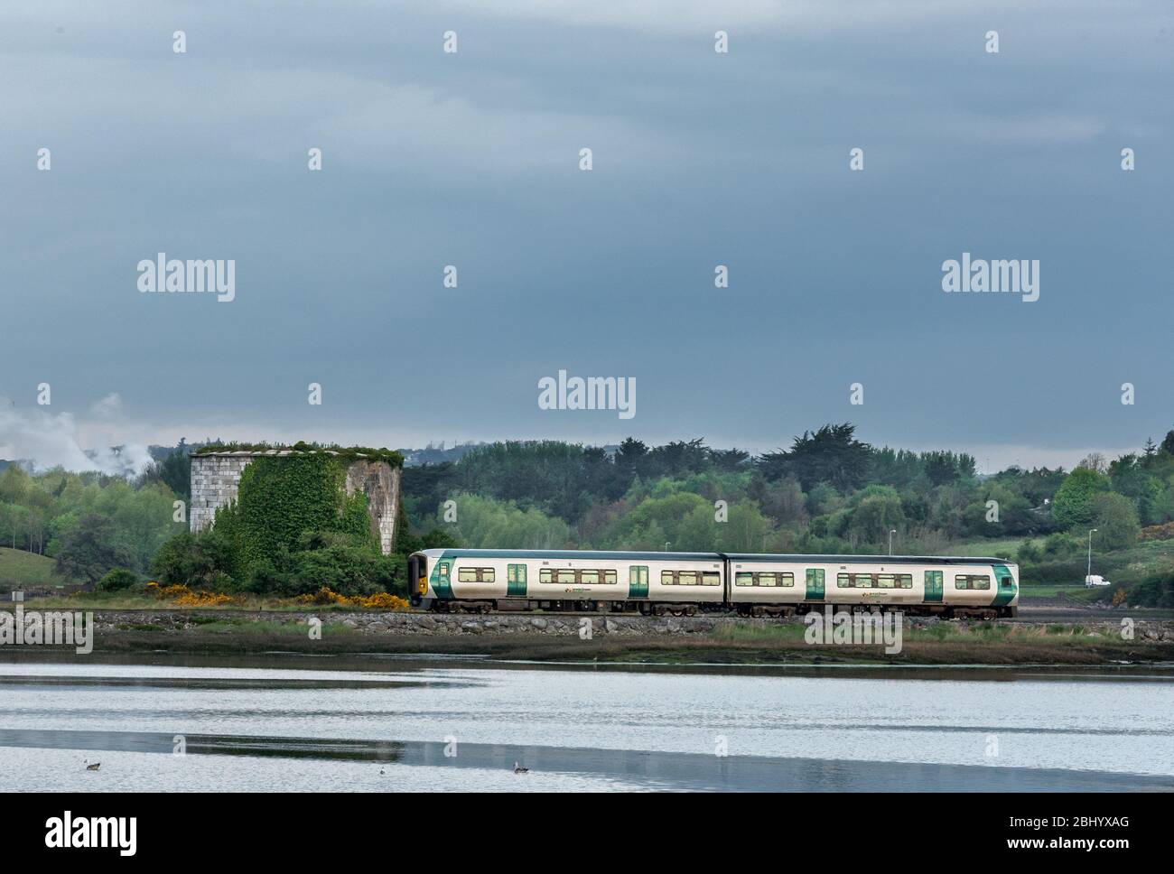 Fota Island, Cork, Ireland. 28th April, 2020. An early morning commuter train from Kent station and bound for Cobh passes the Mortello Tower on Fota Island in Co. Cork, Ireland. - Credit; David Creedon / Alamy Live News Stock Photo