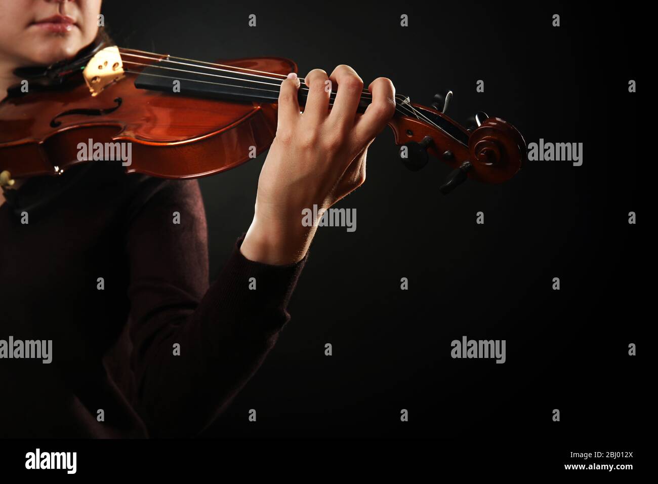 Violinist playing violin on dark background Stock Photo