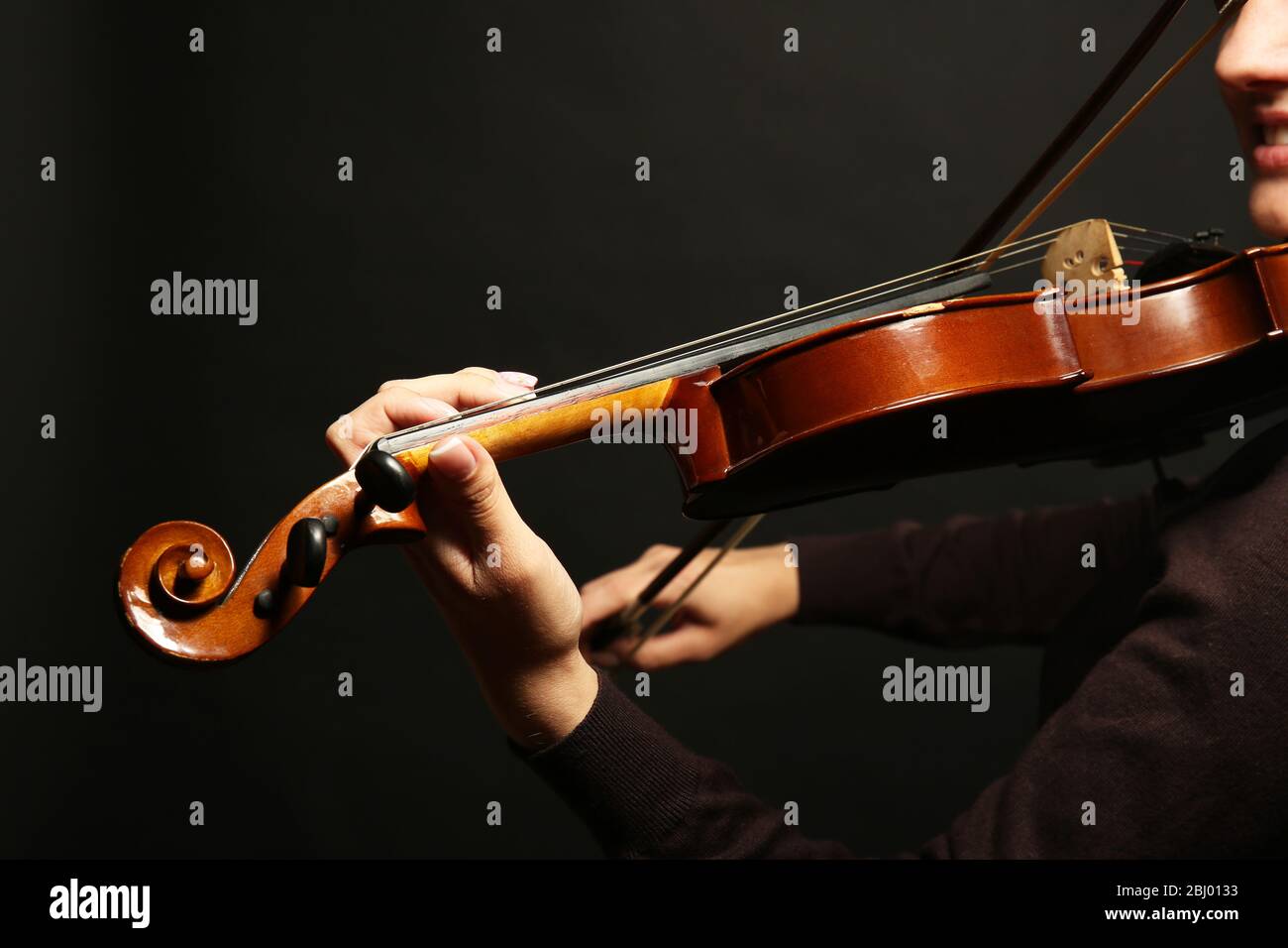 Violinist playing violin on dark background Stock Photo
