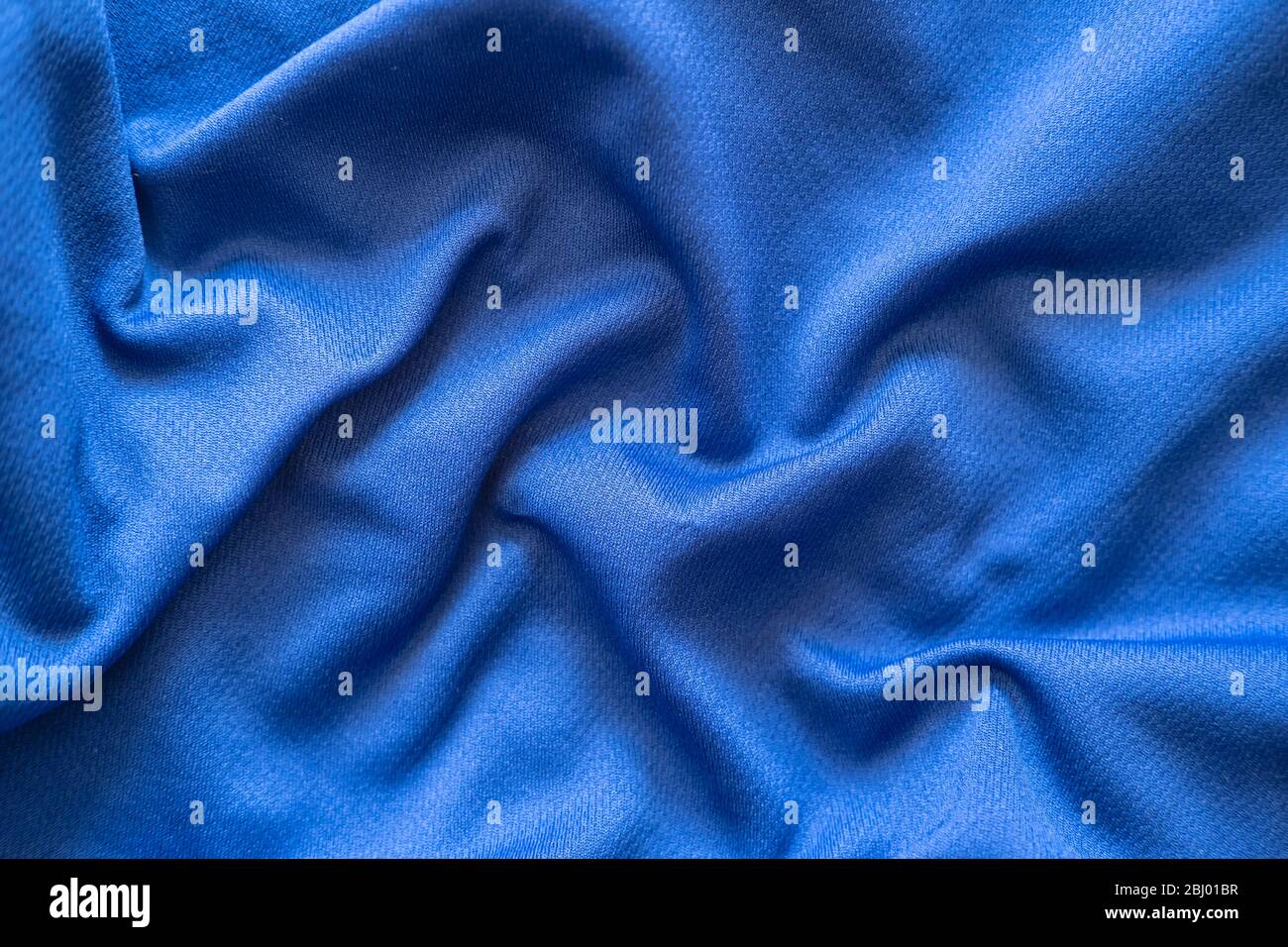 Crumpled blue synthetic fabric. Abstract empty background. Top view. Stock Photo