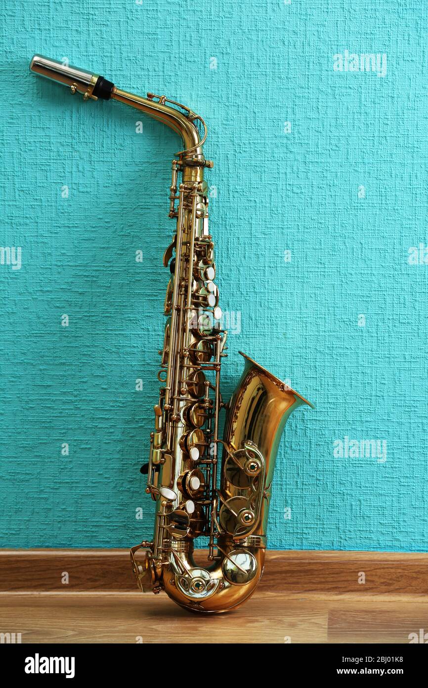 Saxophone on turquoise wallpaper background Stock Photo  Alamy