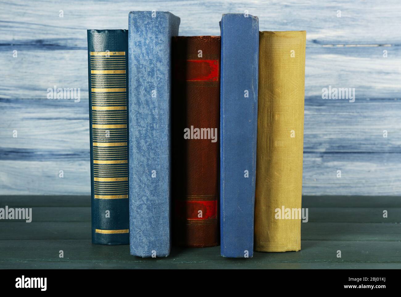 Stack of books on wooden table on blue wooden wall background Stock ...