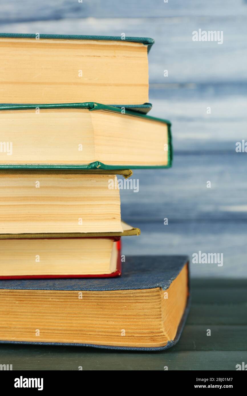 Stack of books on wooden table on blue wooden wall background Stock ...