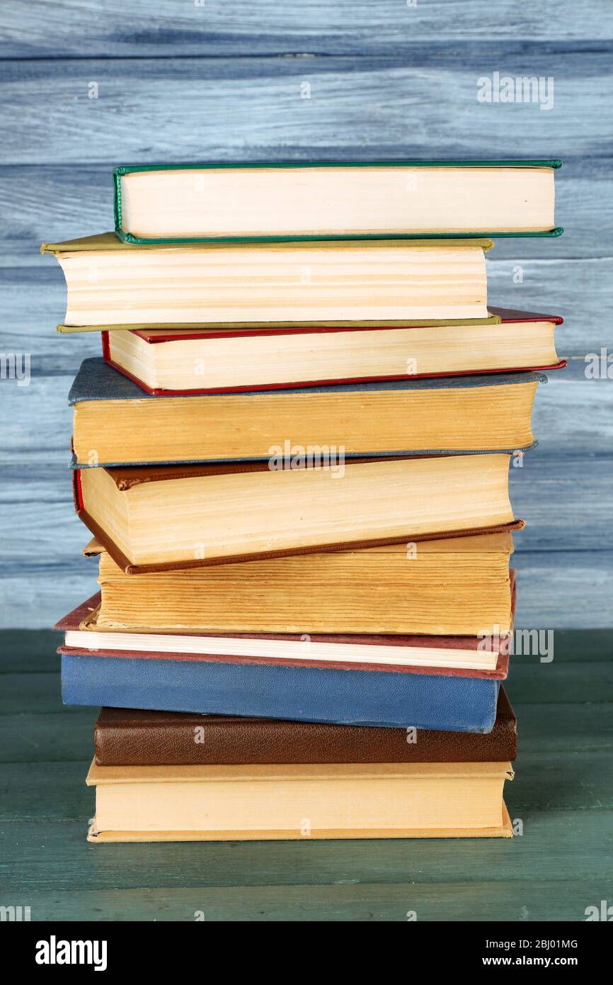 Stack of books on wooden table on blue wooden wall background Stock ...