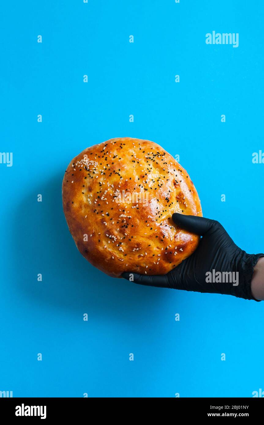 Ramadan pide in a hand with medical gloves. Stock Photo
