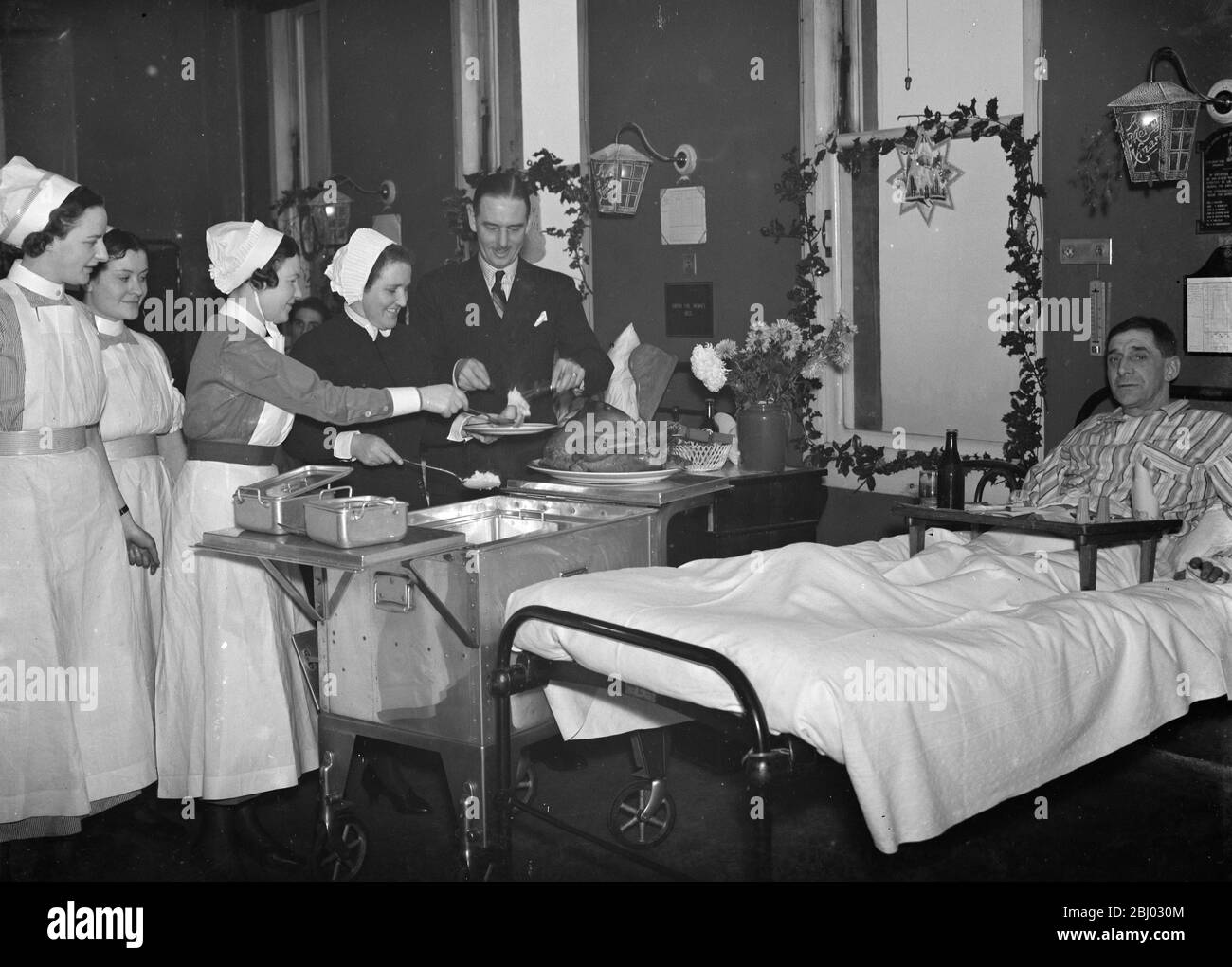 Doctor Sinclair carving the Christmas turkey for the patients on the ward at Erith Hospital . - 1937 Stock Photo