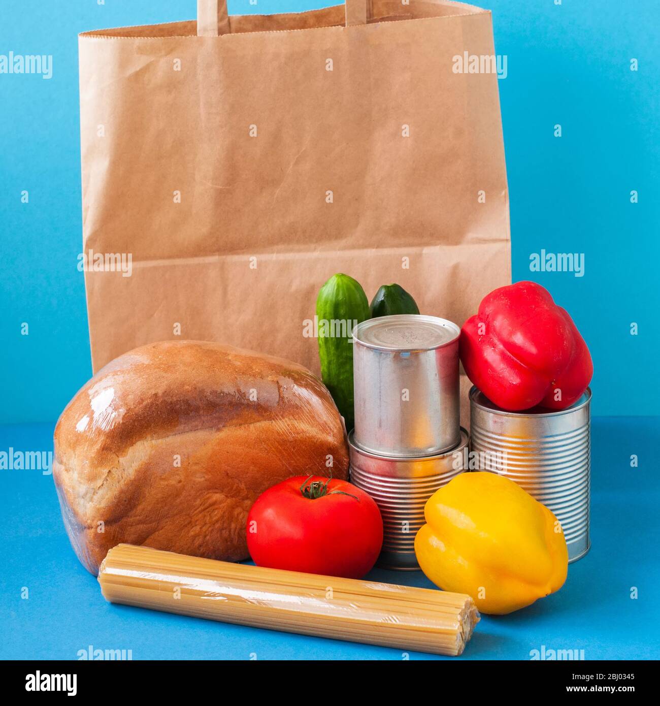 Paper bag with food supplies on blue background.  Stock Photo