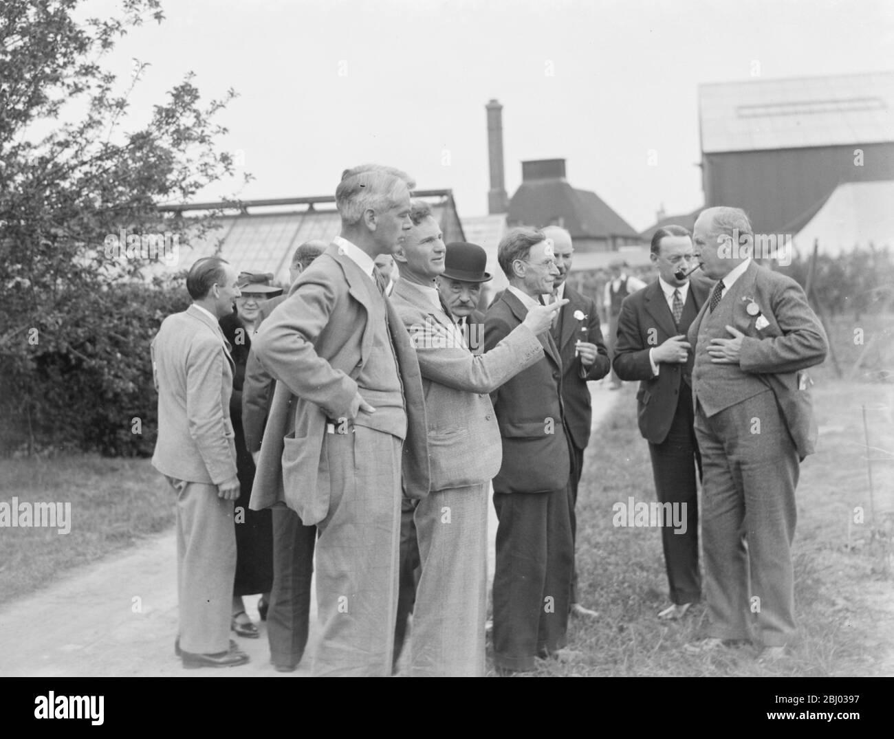 The Right Honourable William Shepherd Morrison , the UK Minister of Agriculture , Fisheries and Food (at the front of the picture) , being show round the East Malling Research Station in Kent . - 1937 Stock Photo