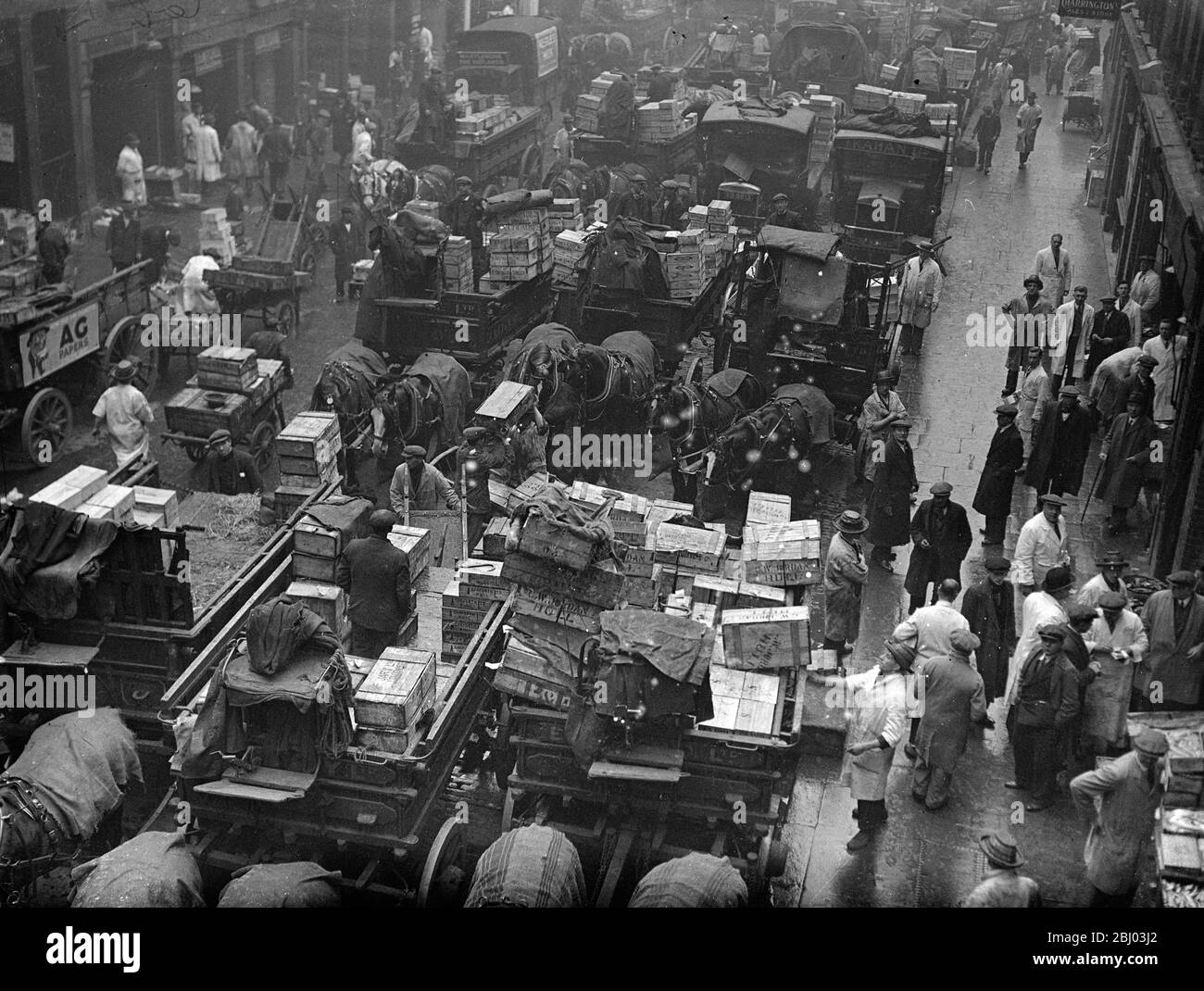 Billingsgate Fish Market is already working at top pressure to deal with the terrific demand for Good Friday fish . The approach of the Easter festival means greatly increased work for Billinsgate , which has to supply eight million Londoners . Photo shows , the busy scene at Billingsate Market . - 4 April 1936 Stock Photo