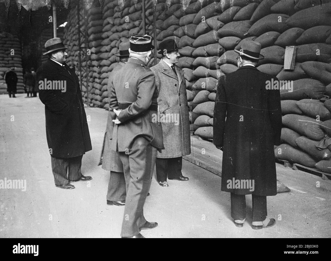 French Minister of Agriculture inspects wheat reserves - International crisis causes apprehension . - M Theillier , Minister of Agriculture ( light coat , dark hat ) inspecting the stores of wheat at Ile St Denis . - 17 March 1935 Stock Photo