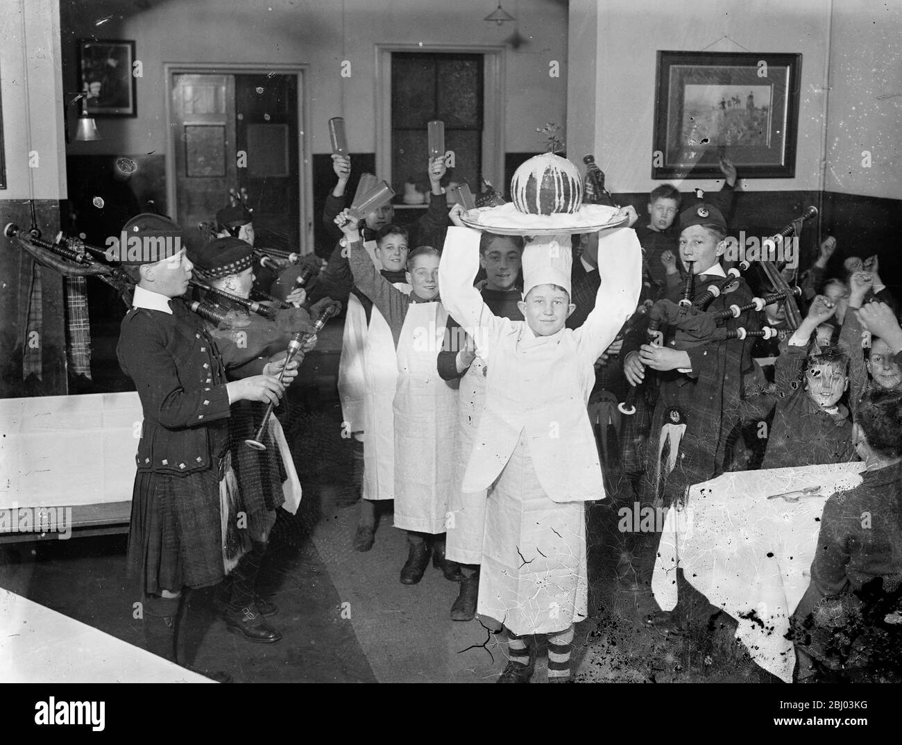 Christmas celebrations have already started at a Barnardo home . - The Christmas festivities have made an early start at Dr Barnardo ' s Dalziel of Wooler Memorial Home , Kingston , where the Christmas puddings were piped in with elaborate ceremony . - Photo shows , boys cheering as a Christmas pudding arrive in full regalia . - 30 November 1935 Stock Photo