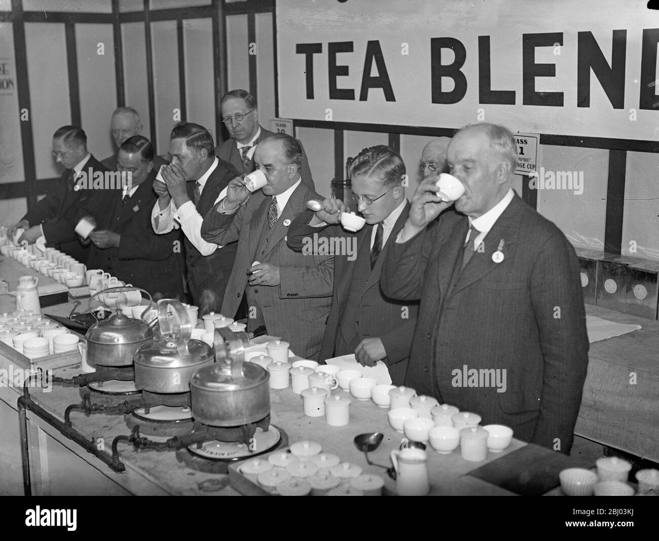 Tea blending competition at grocers exhibition . - The tea blending opens to masters , managers and assistance for ' The Grocer ' Challenge Cup is in progress at the Grocers Exhibition , Royal Agricultural Hall , Islington . - Photo shows , the tea blending competition in progress . - 21 September 1936 Stock Photo