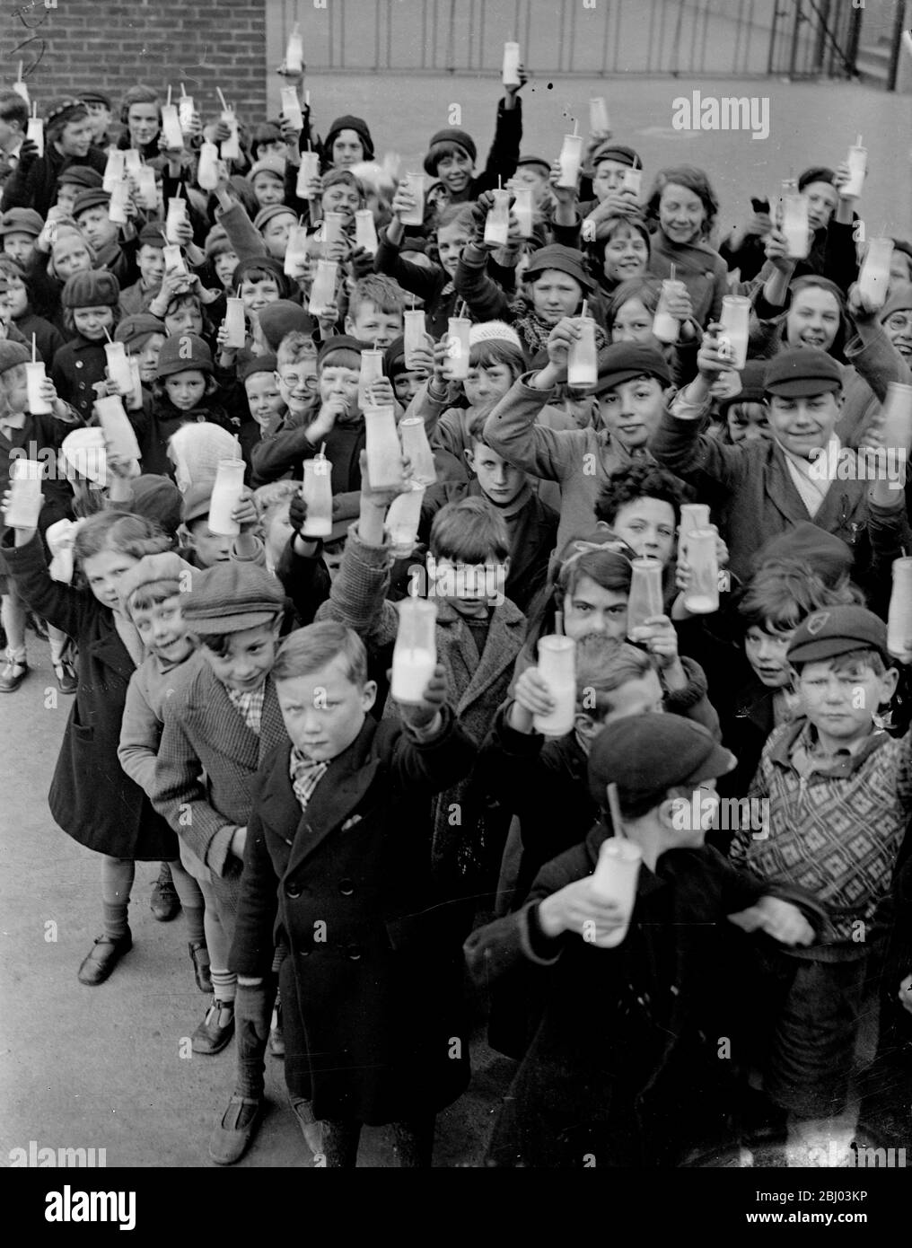 One lesson they like . - Children go to school in their holidays to drink milk . - Though the schools are closed for the holidays , schoolchildren at Carshalton , Surrey , still receive their daily milk . A scheme has been put into operation for supplying milk to the children during the holiday periods . - Six hundred children are attending three schools in the district for half an hour in the morning to drink their milk there . - The milk is paid for by a half penny contribution from the child and a half penny from a grant . Women Volunteers issue the milk . - Photo shows , Carshalton Schoolc Stock Photo