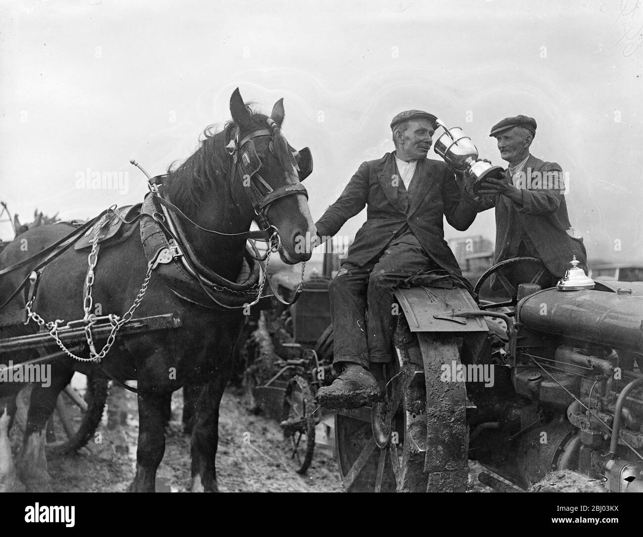 Motor ploughman wins championship at Middlesex ploughing matches . - The champion horse ploughman Mr A Meeds of Bedfont ( left ) takes congratulatory drink from the cup won by Mr W Gatford of Bedfont , the motor ploughman who won the championship ( right ) . - 24 September 1935 Stock Photo