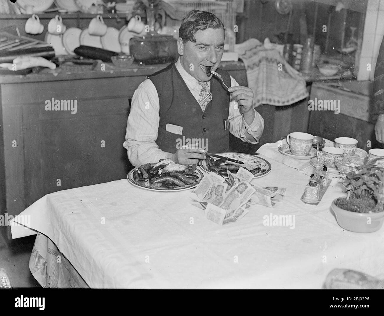 London man wins wager by eating 100 sausages and 10 eggs at a sitting. - To settle a wager of several pounds, Mr George W Brown of Erlanger Road, New Cross, sat down as table and ate of 100 sausages and 10 eggs at a sitting. - The sausages and eggs was specially cooked by Mrs Brown and several of the people who had put down money counted the sausages as they were eaten. - Mr Brown had not done any 'diet training' in preparation for his big meal, and had previously eaten his usual luncheon. - Mr Brown emerged victorious by consuming the sausages and eggs in just under 40 minutes. - Photo shows, Stock Photo