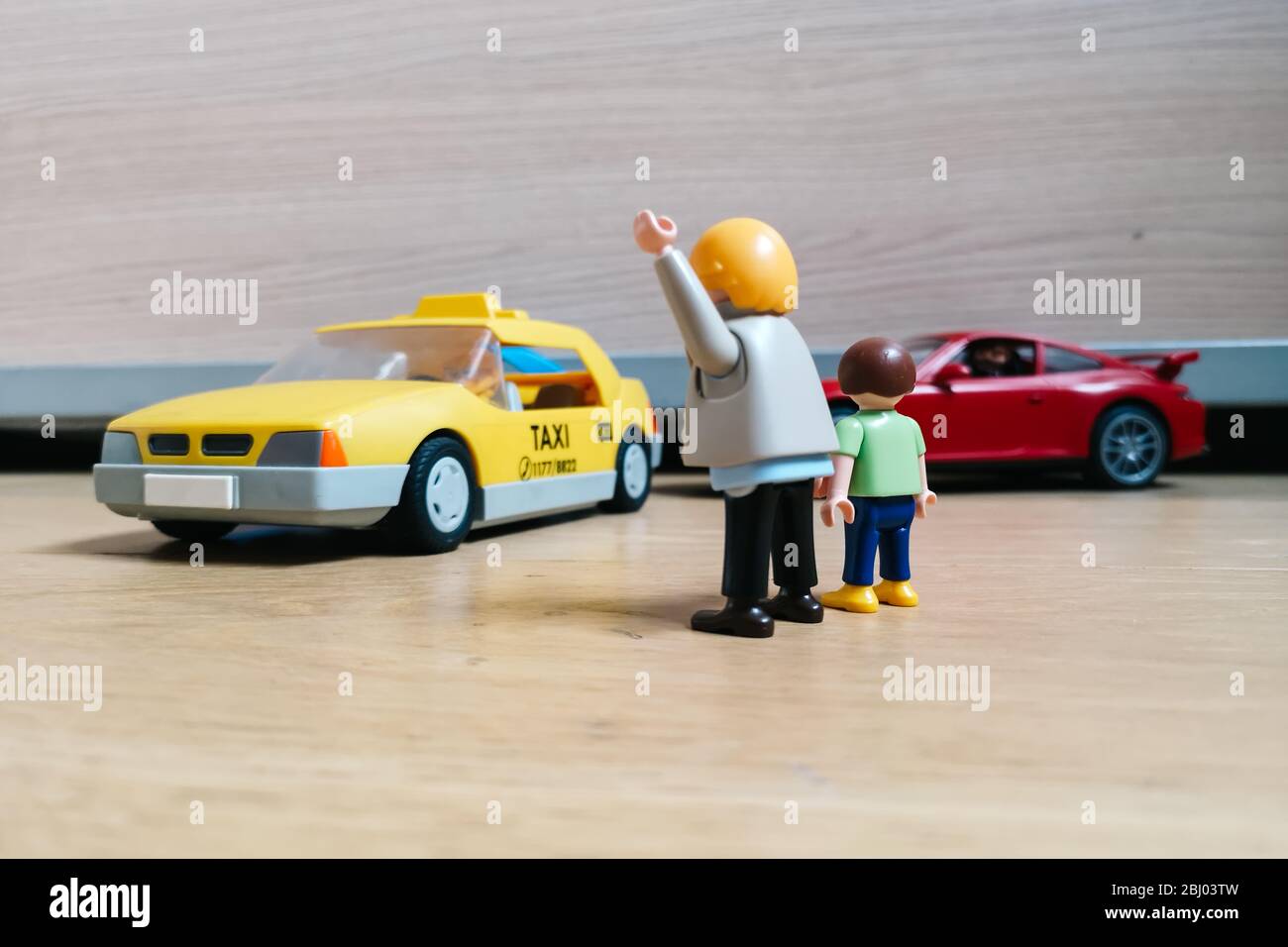 Madrid, Spain - July 13, 2019: Playmobil figurines in scene representing man with child stopping a taxi. Concept public transportation Stock Photo