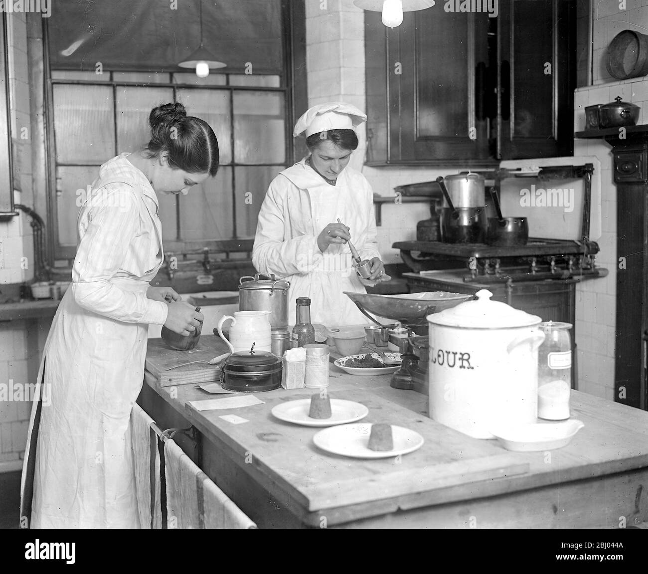Where our war time dishes are invented an experimental kitchen at Grosvenor House started by the Ministry of Food, where all new recipes or suggestions for new methods of cookery are tried. - Cooks at work trying to produce an entirely fatless dinner. - 21st March 1918 Stock Photo